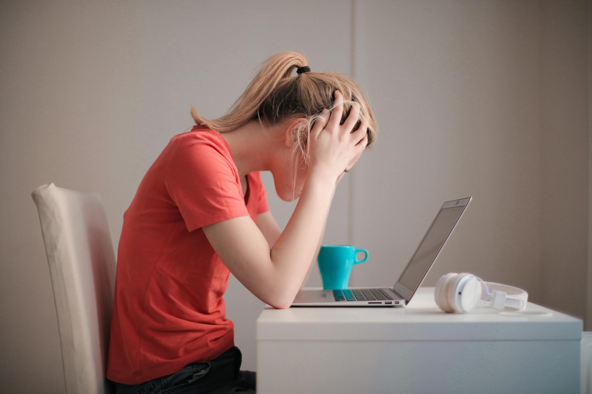 Person looking stressed while working on laptop